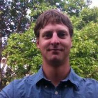 A headshot photo of Dean Vik outside. 