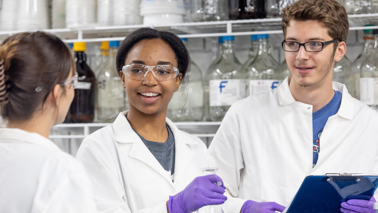 Three scientists discussing results of lab.